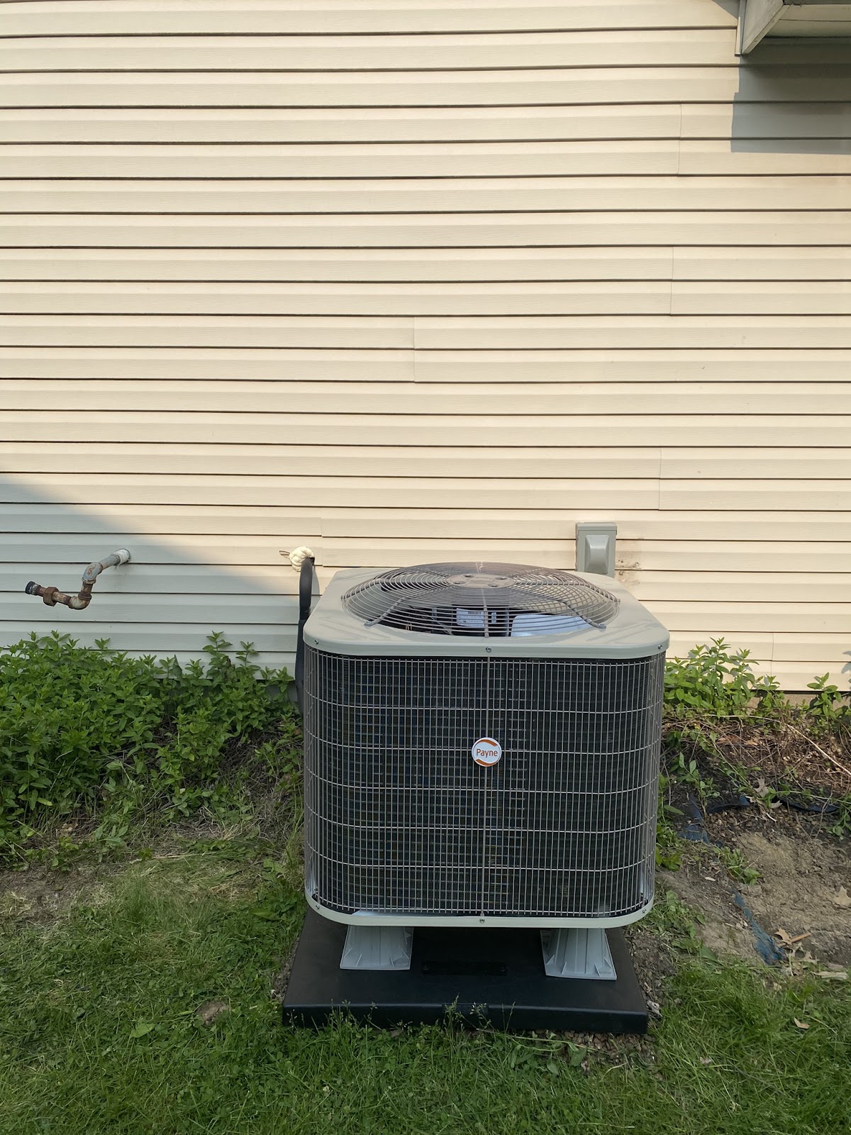 A new outdoor AC unit set on a pad beside a home